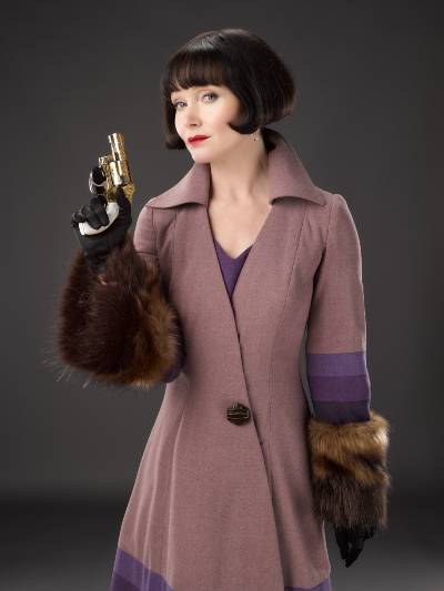Miss Fisher and The Crypt Of Tears fashion photo of Miss Fisher and a pistol
