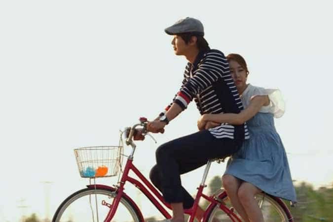 Boong-Do and Hee-Jin ride a bicycle